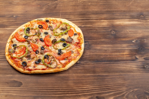 茶色の木の表面においしいチーズピザを正面から見る