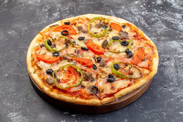 灰色の表面においしいチーズピザを正面から見る