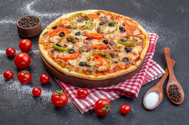 어두운 표면에 빨간 토마토와 전면보기 맛있는 치즈 피자
