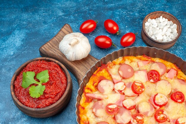 파란색 이탈리아 음식 반죽 케이크 패스트푸드 사진 색상에 소시지와 토마토를 곁들인 맛있는 치즈 피자 전면 보기