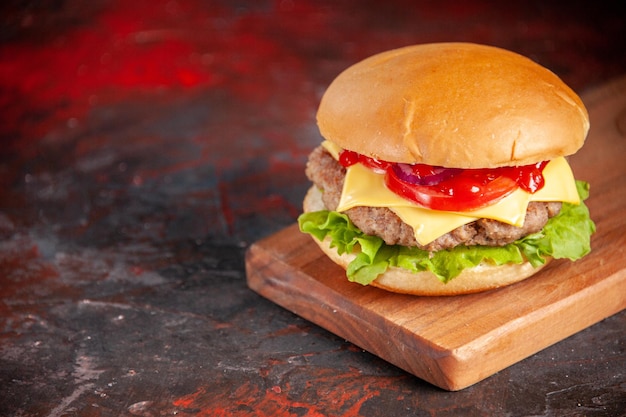 Front view delicious cheeseburger with meat tomatoes and green salad on dark background fast-food meal snack french fries dinner dish sandwich