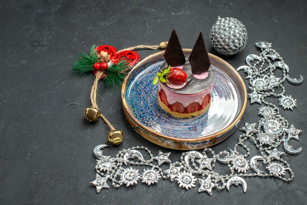 Front view delicious cheesecake with strawberry and chocolate on oval plate xmas ornament on dark free place