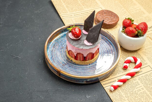 Front view delicious cheesecake with strawberry and chocolate on plate strawberry bowl biscuit xmas candy