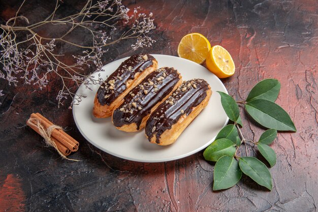 어두운 배경에 접시 안에 전면보기 맛있는 초코 eclairs