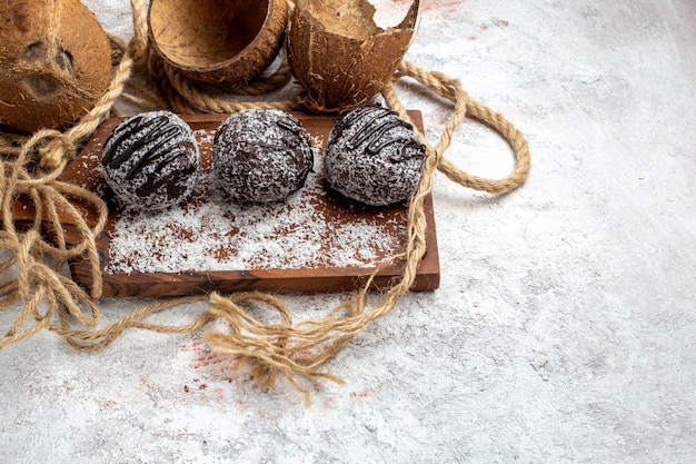 Вид спереди вкусные шоколадные торты с кокосом на белой поверхности бисквитный сахарный торт сладкое чайное печенье