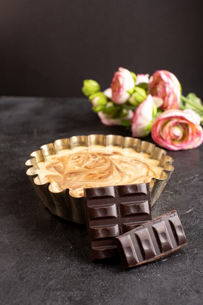 A front view delicious coffee cake sweet chocolate delicious sugar bakery cake sweet along with roses on the dark desk