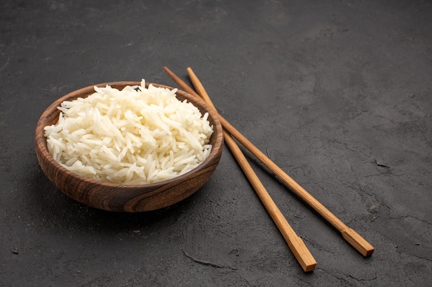 Front view delicious cooked rice plain tasty meal inside plate on dark desk