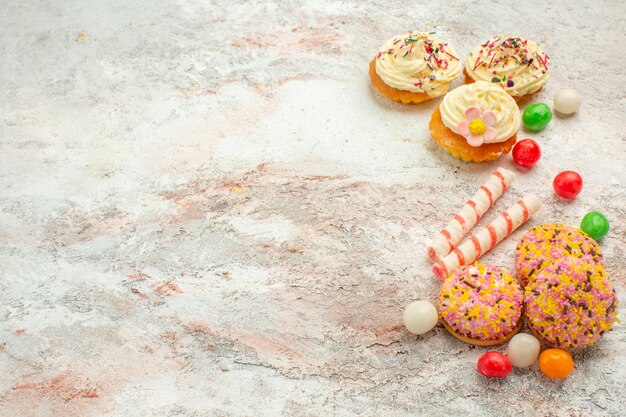 Front view delicious cookie cakes with colorful candies on white background cake biscuit cookie pie color