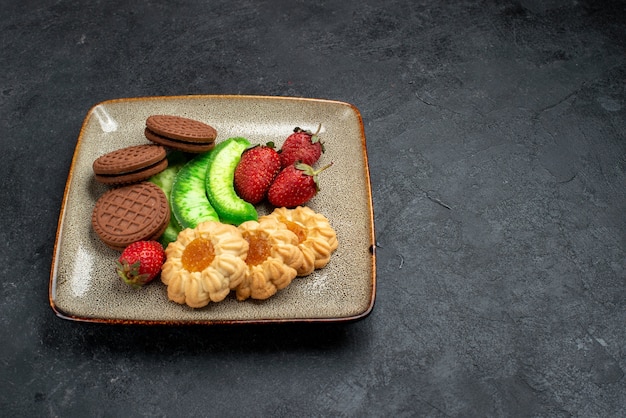 正面図おいしいクッキーチョコレートとダークグレーの壁に新鮮な赤いイチゴのシンプルなもの砂糖ビスケットケーキ甘いクッキー