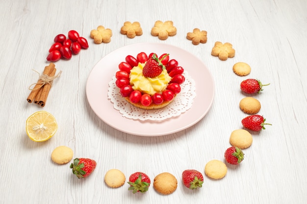 無料写真 正面図白い机の上の果物とケーキとおいしいクッキーフルーツティービスケットデザート
