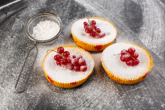 Front view of delicious cranberry cakes baked and yummy with red cranberries on top grey surface