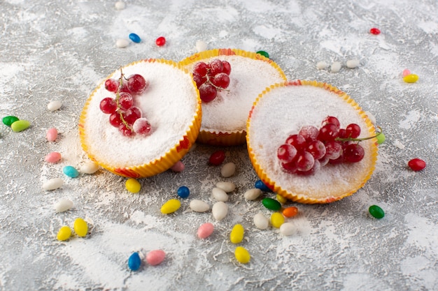 Front view of delicious cranberry cakes with red cranberries on top sugar pieces and powder