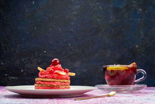 Вид спереди вкусный кремовый торт с чашкой чая на темной поверхности