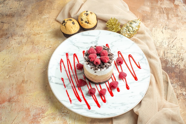 Free photo front view delicious creamy cake inside plate with fresh raspberries on brown table