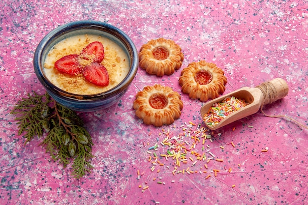 밝은 분홍색 벽에 빨간색 슬라이스 딸기와 쿠키가있는 전면보기 맛있는 크림 디저트 디저트 아이스크림 크림 달콤한 베리 과일