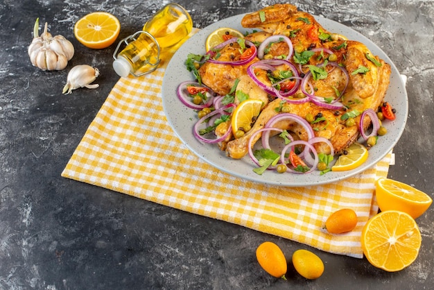 Vista frontale di una deliziosa cena piatto di pollo fritto con varie spezie e cibi garlics olio caduto bottiglia di limone sul lato sinistro su sfondo di colore scuro