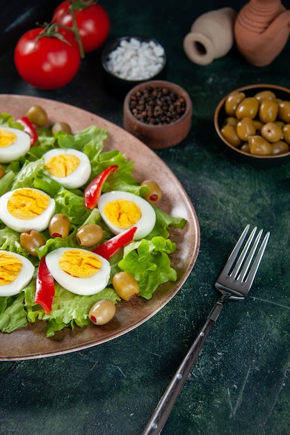 front view delicious egg salad consists of green salad and olives on dark background