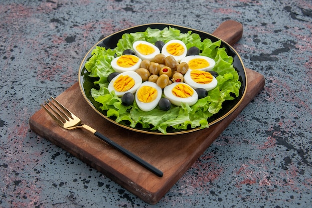 Free photo front view delicious egg salad green salad and olives on light background