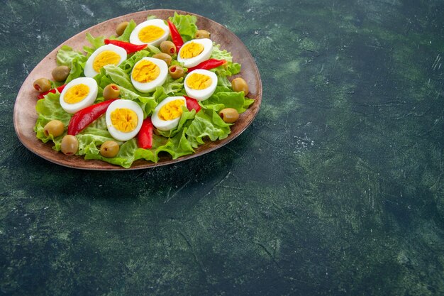 front view delicious egg salad with green salad and olives on dark blue background