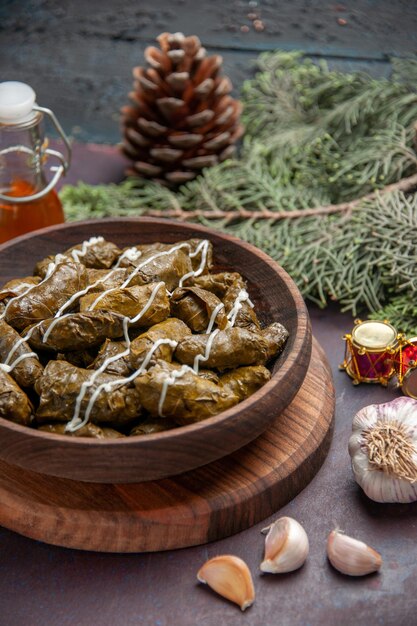 Front view delicious leaf dolma meat dish with seasonings on a dark space