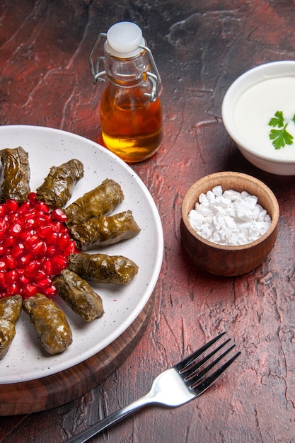 Front view of delicious leaf dolma with seasonings on the dark surface
