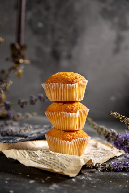 A front view delicious little cakes with purple flowers on the grey table cookie tea biscuit sweet
