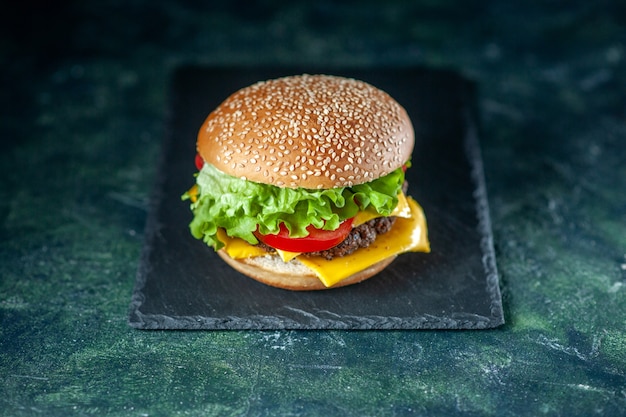 front view delicious meat hamburger with green salad cheese and tomatoes on dark background