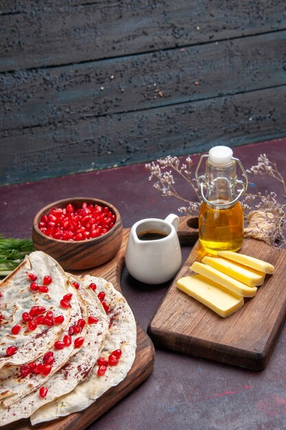 Front view delicious meat qutabs pitas with fresh red pomegranates on dark surface dough pita meat meal food