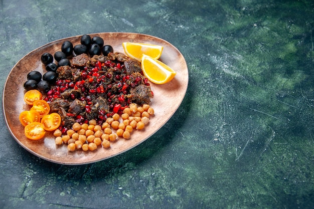 front view delicious meat slices fried with beans grapes and lemon slices inside plate on dark background