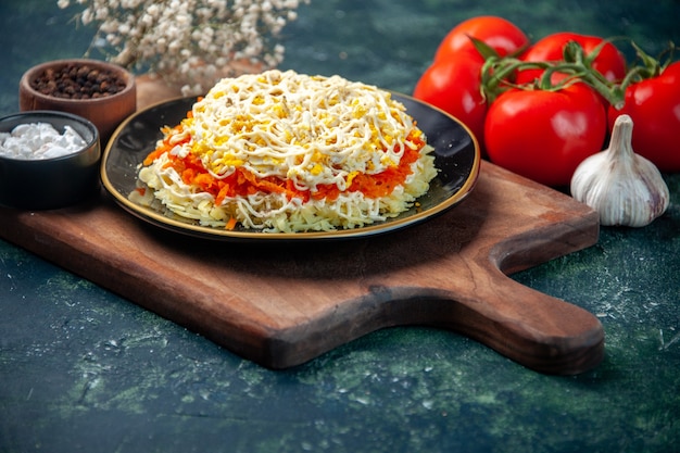 вид спереди вкусный салат с мимозой внутри тарелки с красными помидорами на темно-синей поверхности еда кухня фото еда день рождения цвет мясо кухня