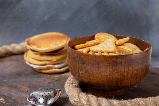 Front view of delicious muffins round formed with crisps on the wooden surface