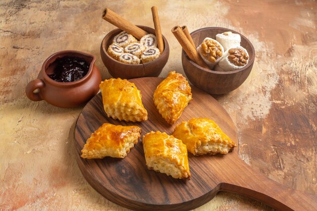 Front view of delicious nut cakes with confitures on wooden surface