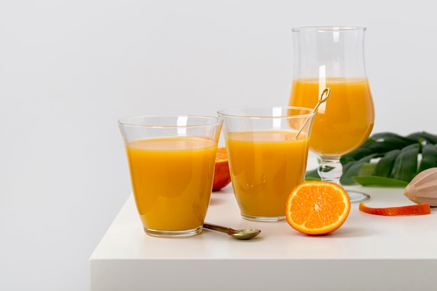 Free photo front view delicious orange smoothies assortment