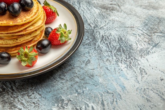 Free photo front view delicious pancakes with fruits and berries on dark surface cake fruit dessert