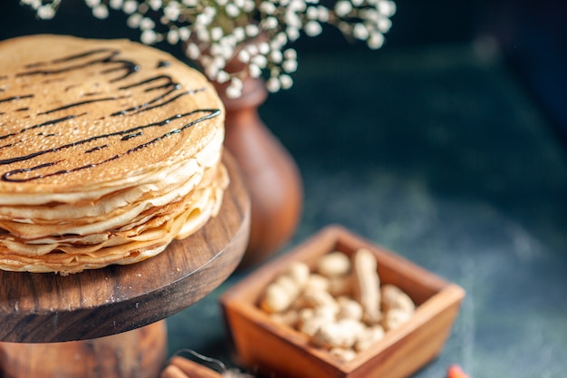 Front view delicious pancakes with milk and nuts on dark blue milk dessert breakfast honey morning pie cake