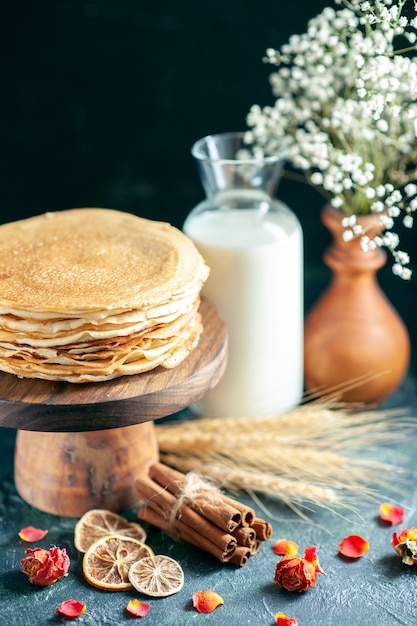 Вид спереди вкусные блины на деревянном столе и темный пирог с завтраком, сладкий мед, утренний чай, десерт