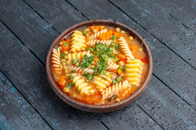 Front view delicious pasta soup from spiral italian pasta with greens on a dark desk dish italian pasta dinner sauce soup