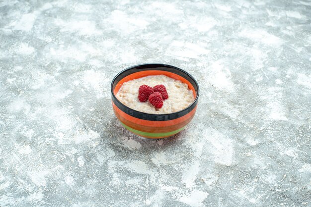 Front view delicious porridge with raspberries on light table