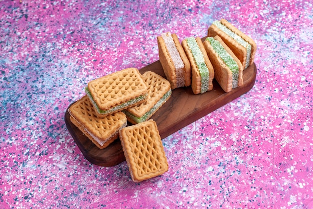 Biscotti deliziosi del panino di vista frontale sulla scrivania rosa.