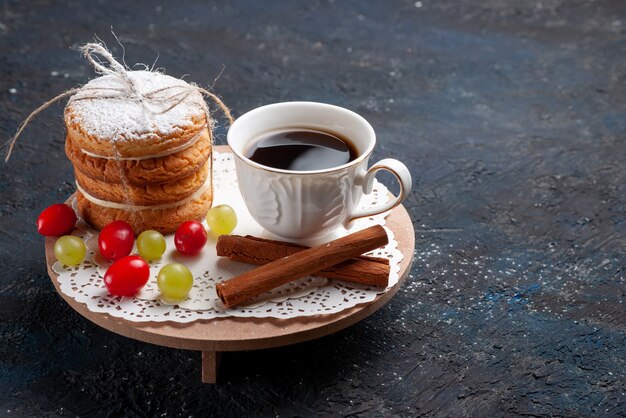 Front view delicious sandwich cookies tied yummy with sliced fruits cinnamon and coffee on the dark-blue surface cake 