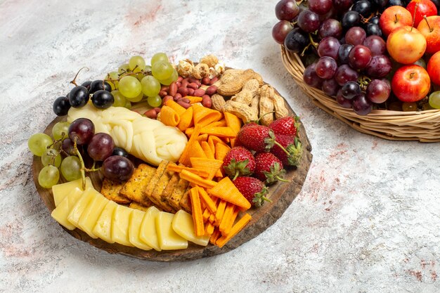 Вид спереди вкусные закуски, чипсы, виноград, сыр и орехи на белом пространстве