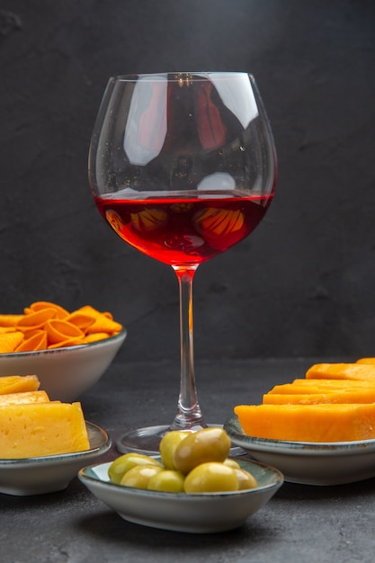 黒の背景にガラスのゴブレットでワインのおいしい軽食の正面図