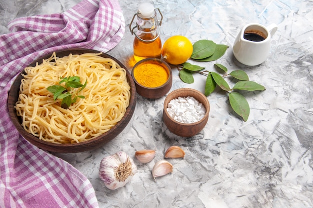 Вид спереди вкусные спагетти внутри тарелки на белом столе, блюдо из теста для макарон