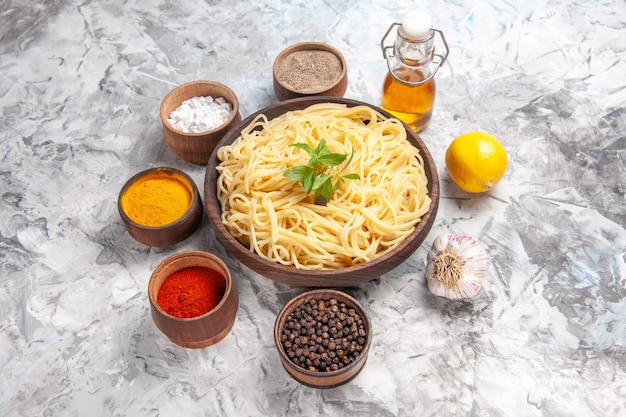 Delicious Spaghetti with Seasonings: A Mouthwatering Meal on a White Table