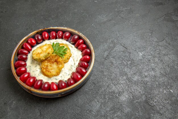 Free photo front view delicious squash meal with fresh red dogwoods on a grey space