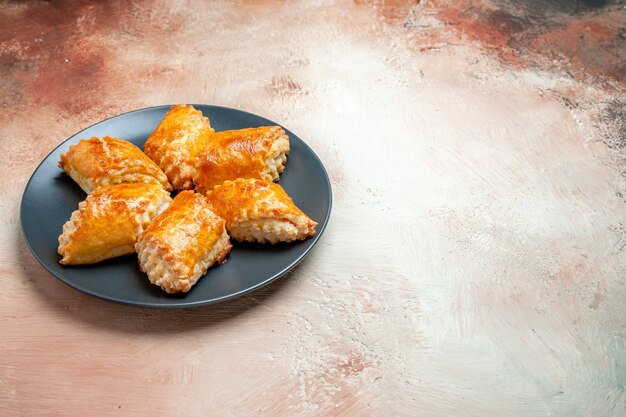 Front view delicious sweet pastries inside plate on the white table pie cake pastry sweet