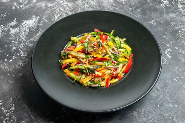 Front view delicious vegetable salad inside plate on grey table