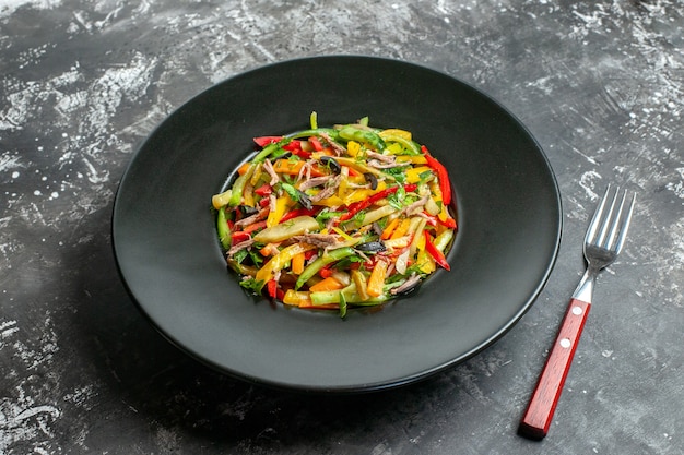 Front view delicious vegetable salad inside plate on grey table