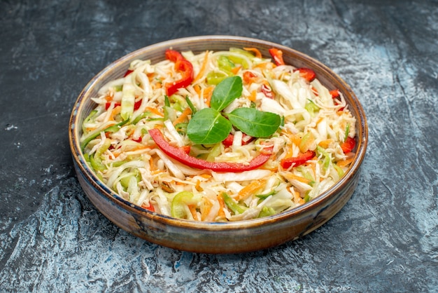 Front view delicious vegetable salad inside tray on grey table