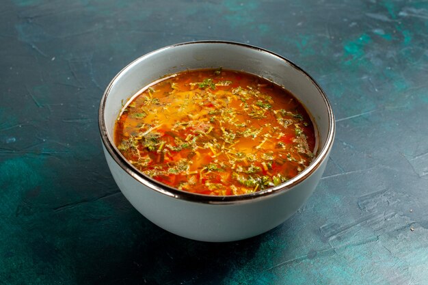 Front view delicious vegetable soup inside plate on dark-green surface